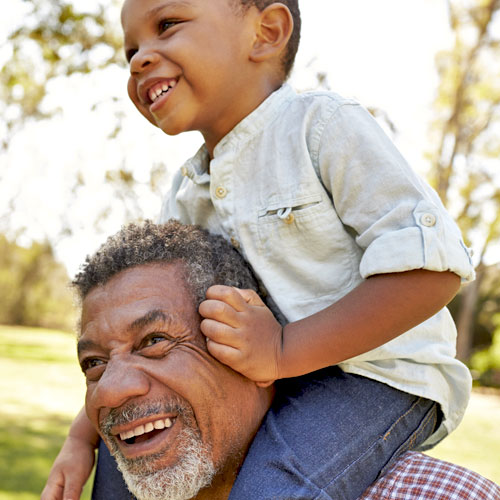 A small boy rides on his father